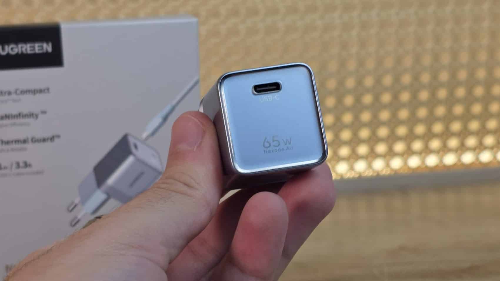 Chargeur UGREEN Nexode Air 65W tenu dans la main, port USB-C visible