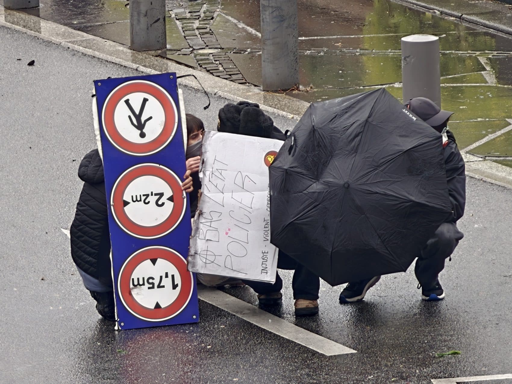 Photo prise avec l’Oppo Find X10 Pro Max : panneaux et parapluie dans la rue